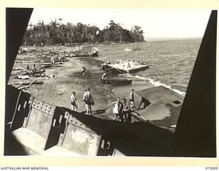 MALAHANG BEACH, NEW GUINEA. 1944-05-14. ALLIED AND AUSTRALIAN TROOPS BATHING IN THE AREA NEAR LAE. THE REMAINS OF THE JAPANESE MERCHANT SHIP MYOKO MARU, WHICH WAS BEACHED AFTER RECEIVING EXTENSIVE ..