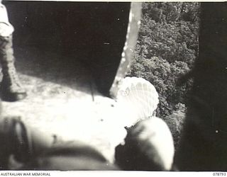 PEARL RIDGE AREA, BOUGAINVILLE ISLAND. 1945-01-30. PERSONNEL OF THE SOLOMON'S DETACHMENT, 12TH AIR MAINTENANCE PLATOON (TS), 4TH BASE SUB AREA, DROPPING SUPPLIES FROM ONE OF THEIR AIRCRAFT TO ..