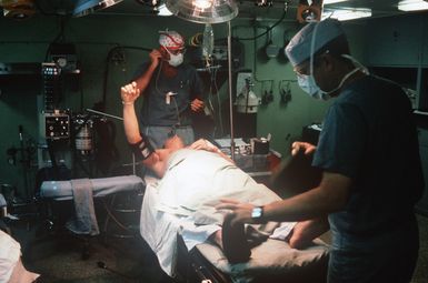 A surgeon takes a blood pressure reading on a crew member in an operating room aboard the amphibious assault ship USS SAIPAN (LHA 2)