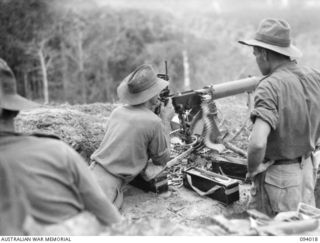 WEWAK AREA, NEW GUINEA, 1945-07-14. A VICKERS MEDIUM MACHINE-GUN PROVIDING COVERING FIRE AS A COMPANY, 2/8 INFANTRY BATTALION, WITH B COMPANY IN SUPPORT, PREPARES FOR THEIR FINAL DASH FOR THE TOP ..