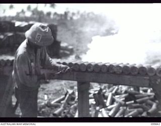 RABAUL, NEW BRITAIN, 1946-02-19. A JAPANESE EXPLODING THE PRIMERS OF 3-INCH SHELLS DURING THE MASS DESTRUCTION OF ENEMY AMMUNITION. DUMPING OPERATIONS OF JAPANESE AMMUNITION AND EXPLOSIVES WERE ..