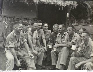 KIRIWINA, TROBRIAND ISLANDS, PAPUA. 1944-01-18. AN INFORMAL GROUP PORTRAIT OF MANLY AND DISTRICT SURF CLUB IDENTITIES WHO GATHERED FOR A "POT" OF TEA OUTSIDE A HUT AT A RAAF ADVANCED OPERATIONAL ..