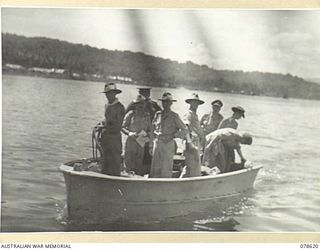 JACQUINOT BAY, NEW BRITAIN. 1945-01-12. MAJOR-GENERAL J.A. BAILLON OF THE BRITISH ARMY GENERAL STAFF AND N373078 CHAPLAIN GENERAL A.M. STEVENSON, MC, ED, WITH THE OFFICIAL PARTY IN A LAUNCH. NOTE ..