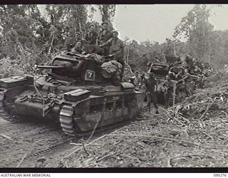 BOUGAINVILLE. 1945-03-30. NO 7 AND NO 9 TROOP, B SQUADRON, 2/4TH ARMOURED REGIMENT TANK CREWS WAITING ON THE TOKO-DARARA ROAD FOR ENGINEERS TO REPLACE THE BRIDGE TO ALLOW TANKS TO CROSS. THIS IS ..