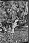 Ritual exchange: men measure strand of cowrie shells against blade of stone axe