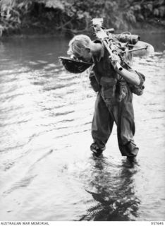 MARINGGUSIN, NEW GUINEA, 1943-09-29. VX116662 PRIVATE G. ALLEN, "A" COMPANY, 2/14TH AUSTRALIAN INFANTRY BATTALION, DRINKING WATER FROM HIS STEEL HELMET WHILE CROSSING THE YATI RIVER, DURING THE ..