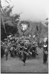 Bride price for Maima: Molo the groom's group dances with payment banner of feather and shell valuables for bride's clan