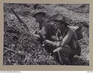 WEWAK POINT, NEW GUINEA. 1945-05-10. PRIVATE G.P. WILSON, WITH RIFLE (1), AND PRIVATE W.A. RILEY, WHO HOLDS A 2 INCH MORTAR (2). THE MEN, MEMBERS OF 2/4 INFANTRY BATTALION, ARE ADVANCING AGAINST ..