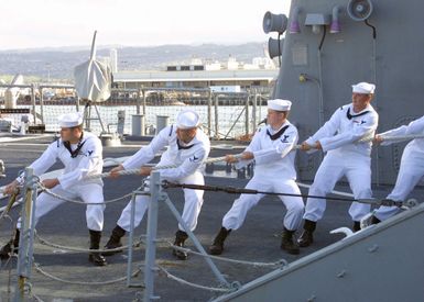 US Navy (USN) line handlers onboard the USN Arleigh Burke Class Guided Missile Destroyer, USS PAUL HAMILTON (DDG 60) assist during the mooring as the ship settles into its berth at Pearl Harbor, Hawaii (HI). The PAUL HAMILTON returned home after a deployment spanning more than nine months for Operation IRAQI FREEDOM