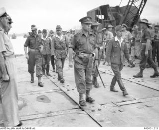 The Japanese surrender party, with an Australian escort led by Brigadier J Field, Commander 7th Australian Brigade, moves off from the waterfront at Torokina, Bougainville Island, towards the site ..