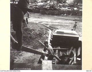 ALEXISHAFEN, NEW GUINEA. 1944-07. MEMBERS OF THE 4TH FIELD COMPANY, ROYAL AUSTRALIAN ENGINEERS REMOVE BURNT OR ROTTED TIMBER FROM THE UPPER STOREY OF THE PRIEST'S RESIDENCE IN THE MISSION AT SOUTH ..