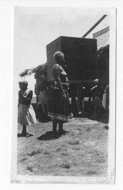 [Bougainvillean Woman Standing Near a Large Box]