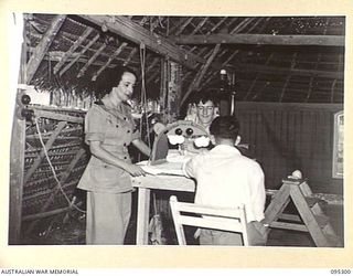 PALMALMAL PLANTATION, JACQUINOT BAY, NEW BRITAIN, 1945-08-14. LIEUTENANT J.E. TRUMAN, AUSTRALIAN ARMY MEDICAL CORPS PHYSIOTHERAPIST (F) GIVING PHYSIOTHERAPY TREATMENT AT THE 2/8 GENERAL HOSPITAL