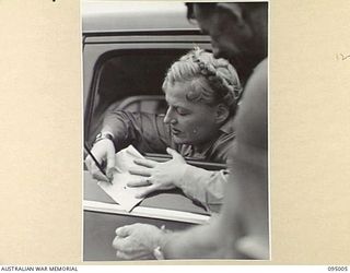 LAE AREA, NEW GUINEA. 1945-08-18. MISS GRACIE FIELDS SIGNING AUTOGRAPHS DURING HER VISIT TO THE LAE AREA