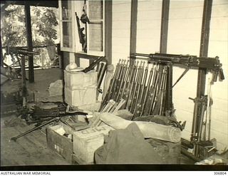 NEW GEORGIA, SOLOMON ISLANDS. 1943-03. PART OF THE COASTWATCHERS ARSENAL OF UNITED STATES AND CAPTURED JAPANESE WEAPONS HELD BY CAPTAIN D.G. KENNEDY, BRITISH SOLOMON ISLANDS PROTECTORATE DEFENCE ..