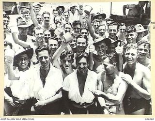 NEW GUINEA. 1943-11-19. RED CROSS WORK AT A PICNIC HELD NEAR THE AUSTRALIAN FIELD HOSPITAL. GROUP PORTRAIT OF SMILING CONVALESCENTS ANSWER A CALL FOR REFRESHMENTS