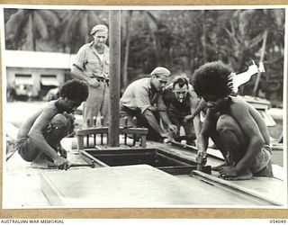 KWIARA, CHINA STRAITS, 1943-07-06. NATIVE WORKERS AND MEMBERS OF THE 1ST AUSTRALIAN WATER TRANSPORT GROUP MAINTENANCE BASE, AT WORK ON THE AM-48