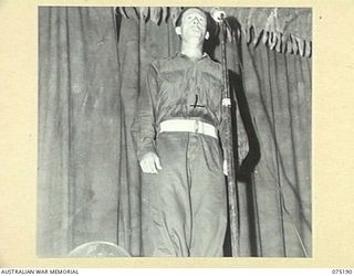 LAE, NEW GUINEA. 1944-08-11. A SOLOIST RENDERING AN ITEM DURING THE CONCERT STAGED FOR PATIENTS OF THE 113TH CONVALESCENT DEPOT BY MEMBERS OF THE WHITE HORSE INN CONCERT PARTY. THE CONCERT PARTY ..