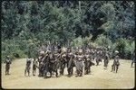 Pig festival, singsing, Kompiai: decorated men enter dance ground, carrying bows and arrows