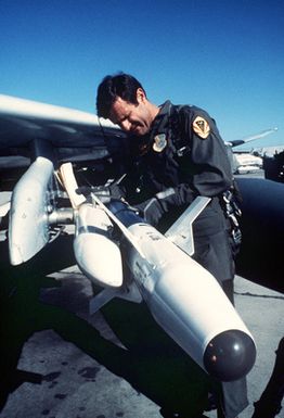 A pilot checks an AIM-9N/P Sidewinder missile aboard an F-4 Phantom II aircraft prior to flight operations during Exercise Cope Thunder '85