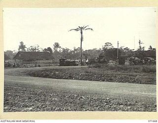 LAE, NEW GUINEA. 1944-03-24. THE GENERAL LAYOUT OF BUILDINGS AT HEADQUARTERS LAE BASE SUB-AREA SHOWING THE REGIMENTAL AID POST TO THE LEFT, AND THE SIGNAL BRANCH LOCATED AMONG ADMINISTRATION ..