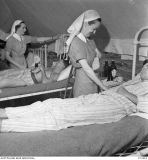 1942-11-11. AUSTRALIAN NURSES RETURN TO NEW GUINEA. THEY ATTEND TO WOUNDED BROUGHT IN FROM THE KOKODA TRACK. LEFT TO RIGHT:- PRIVATE G.A. HAMMOND, N.S.W., SISTER D. BUSH, N.S.W., L/CPL. B.E. DAVIS ..