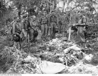 NX200808 Padre Sidney George Stewart, Church of England,officiating at the burial of VX82396 Private (Pte) Lindsay Thomas Dixon on Coconut Ridge. Also seen are, from left to right:  VX82390 Pte ..