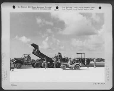 A Dump Truck Empties Its Load Of Smoking Hot Aspalt Into The Tray Of The Aspalt Spreader At The Runway Which The 72Nd See Bees Are Building For The 11Th Bomb Group On Agana Field, Guam, Marianas Islands. October 10, 1944. (U.S. Air Force Number 70543AC)