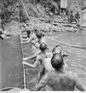 ZENAG, NEW GUINEA, 1944-02-27. A SPORTS CARNIVAL HELD IN A CREEK DAMMED BY PERSONNEL OF THE 2/9TH FIELD COMPANY, ROYAL AUSTRALIAN ENGINEERS. THESE COMPETITORS IN THE "BUN AND TREACLE" RACE, ..