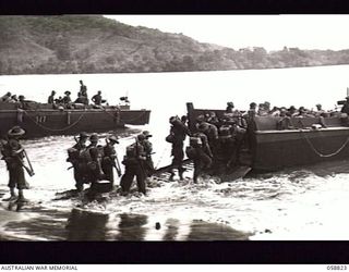 LANGEMAK BAY, NEW GUINEA. 1943-10-20. TROOPS OF THE 2/24TH AUSTRALIAN INFANTRY BATTALION GOING ABOARD A LANDING CRAFT EN ROUTE FOR LAUNCH JETTY AND THE FINSCHHAFFEN CAMPAIGN BATTLE AREA