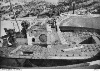 PORT MORESBY, NEW GUINEA. 1944-07. THE NO.1 GUN AT BASILISK BATTERY, 801ST ANTI-AIRCRAFT AND COAST ARTILLERY, HEADQUARTERS MORESBY BASE SUB-AREA, DURING THE COURSE OF ITS ASSEMBLY. THIS PICTURE ..