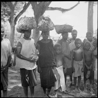 Three women and several children walking to the Boong, native markets, Rabaul, New Guinea, ca. 1936 / Sarah Chinnery