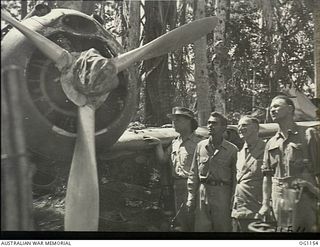 HOLLANDIA, DUTCH NEW GUINEA. C. 1944-06. THE MINISTER FOR AIR, ARTHUR DRAKEFORD (SECOND FROM RIGHT), AND THE MINISTER FOR WAR ORGANISATION OF INDUSTRY, JOHN DEDMAN (RIGHT, WEARING BRACES), WATCH A ..