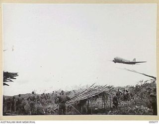 KIARIVU, NEW GUINEA, 1945-08-06. A DOUGLAS C47 DAKOTA AIRCRAFT ZOOMING CLOSE TO THE TOP OF THE INTERMEDIATE OBJECTIVE OCCUPIED BY 2/7 INFANTRY BATTALION WHO ARE ON A SIX DAY PATROL INTO ENEMY ..