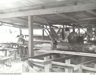 LAE BASE AREA, NEW GUINEA. 1944-12-01. NX55112 PRIVATE W.M. BOWER (1) AND N446986 PRIVATE D. ROFLE (2), WORKING IN THE SAWMILL OF THE 22ND WORKS COMPANY