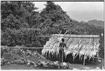 Woman and menstrual hut, with Sinalagu habour below