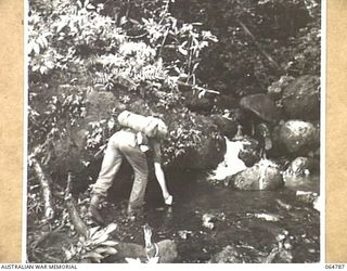 UBERI AREA, NEW GUINEA. 1943-12-19. A MEMBER OF THE 2/9TH INFANTRY BATTALION, WHO ACTED AS AN EXTRA DURING THE FILMING OF THE FINAL SEQUENCES OF THE "RATS OF TOBRUK" WHICH WAS PRODUCED BY CHAUVEL ..