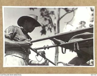 12 MILE, PORT MORESBY AREA, NEW GUINEA. 1943-12-03. NX89664 LANCE CORPORAL H. W. R. OUTLAW OF THE 2ND AUSTRALIAN MOTOR AMBULANCE CONVOY DEMONSTRATING A NEW JEEP AMBULANCE BUILT BY THE UNIT