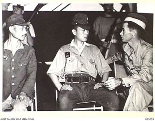 AT SEA, OFF BUIN, BOUGAINVILLE, 1945-08-20. DURING PRELIMINARY SURRENDER DISCUSSIONS ON BOARD THE CORVETTE HMAS LITHGOW, LIEUTENANT H.J. JENKINS, ALLIED TRANSLATOR AND INTERPRETER SECTION (3), IS ..