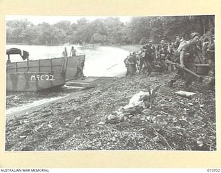 KARKAR ISLAND, NEW GUINEA. 1944-06-02. MEMBERS OF A AND C COMPANY, 37/52ND INFANTRY BATTALION MOVE FROM AMERICAN LANDING BARGES AT BISON BAY DURING THE SECOND WAVE OF THE ATTACK ON THE ISLAND. ..