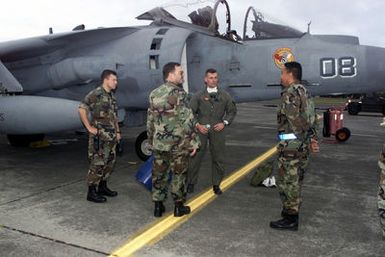 Straight on medium shot as US Marine Major RT Wolfe (In flight suit) of VMA 223 debriefs with SSgt Walter Villegas (Right) (65 OSS) while MSgt Drew Pires (2nd from left) (NCOIC of maintenance for the 65 OSS) and LT Peter Soto (LEFT) (65 OSS CHIEF of maintenance) look on. VMA 223 from Ewa Oahu, Hawaii stopped at Lajes Field on their way to Greece