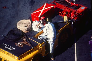 A crash crewman stands by ready for immediate action during flight deck operations aboard the amphibious assault ship USS SAIPAN (LHA-2). The SAIPAN is taking part in Exercise Ocean Venture '81