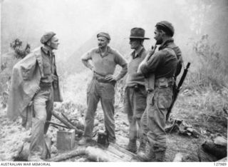 ORODUBI, NEW GUINEA. 1943-07. ON THE SUMMIT OF "TIMBERED KNOLL", NORTH OF ORODUBI, MEN OF THE 2/3RD INDEPENDENT COMPANY WAIT FOR THE MIST TO CLEAR BEFORE MAKING A VISUAL RECONNAISSANCE OF ..