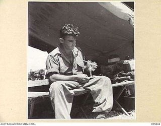 CAPE WOM, WEWAK AREA, NEW GUINEA. 1945-08-30. CRAFTSMAN R.F. GRIFFITHS, 2/4 ARMOURED REGIMENT WORKSHOP, CORPS OF AUSTRALIAN ELECTRICAL AND MECHANICAL ENGINEERS, PUTTING THE FINISHING TOUCHES ON AN ..