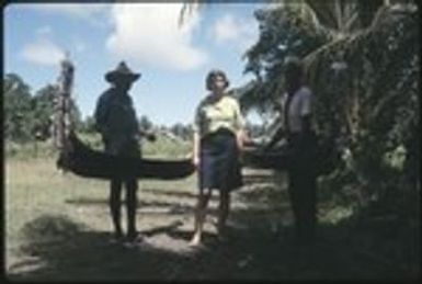 Frances Harwood with two men and miniature canoes