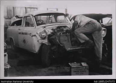 Man working on car after car crash at Fiji