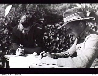 EDIE CREEK, NEW GUINEA. 1943-08-15. NX110936 LIEUTENANT W. J. CROFTS (RIGHT), RETURNING OFFICER OF HEADQUARTERS, ROYAL AUSTRALIAN ENGINEERS, 11TH AUSTRALIAN DIVISION, RECORDS THE VOTE OF NX110949 ..