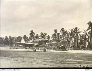 MOMOTE, LOS NEGROS ISLAND, ADMIRALTY ISLANDS. C. 1944-04. THE LIGHT FLASHES GREEN FROM THE CONTROL TOWER, AND THE PILOT OF NO. 76 (KITTYHAWK) SQUADRON RAAF GIVES THE MOTOR FULL GUN AND THE AIRCRAFT ..