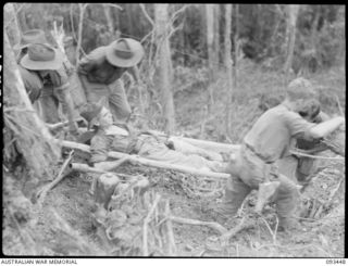 WEWAK AREA, NEW GUINEA, 1945-06-27. PTE V. RILEY, BEING EVACUATED TO AN ADVANCED DRESSING STATION, DURING THE ATTACK BY C COMPANY, 2/8 INFANTRY BATTALION, AGAINST JAPANESE FORCES ON MOUNT ..