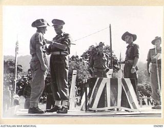 TOROKINA, BOUGAINVILLE. 1945-09-24. MAJOR GENERAL W. BRIDGEFORD, GENERAL OFFICER COMMANDING 3 DIVISION, PINNING THE MILITARY MEDAL ON PRIVATE LANCASTER, 58/59 INFANTRY BATTALION, AT A PRESENTATION ..